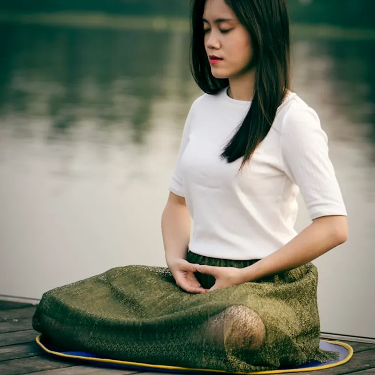 Person seated in meditation on a low bench